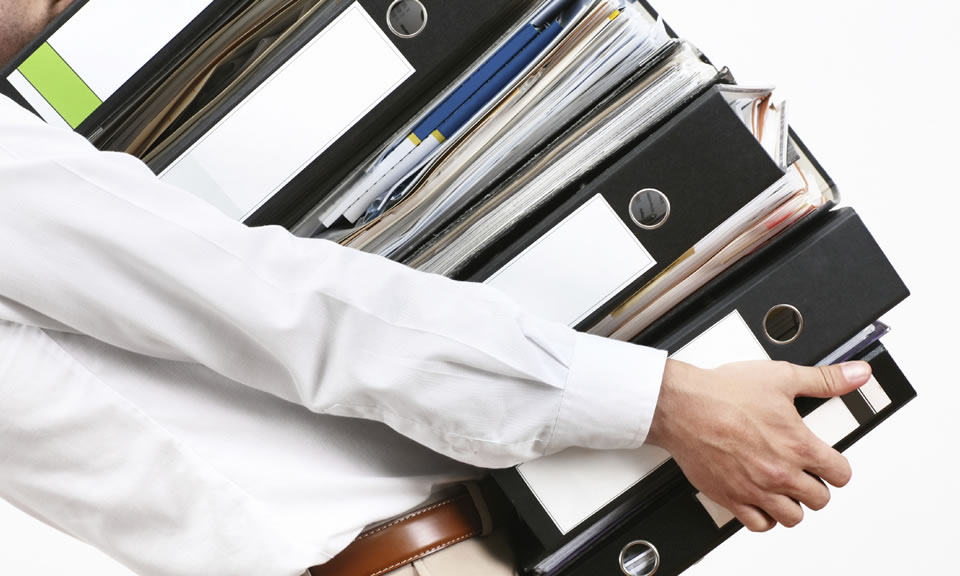 Business man carrying several large 3 ring binders